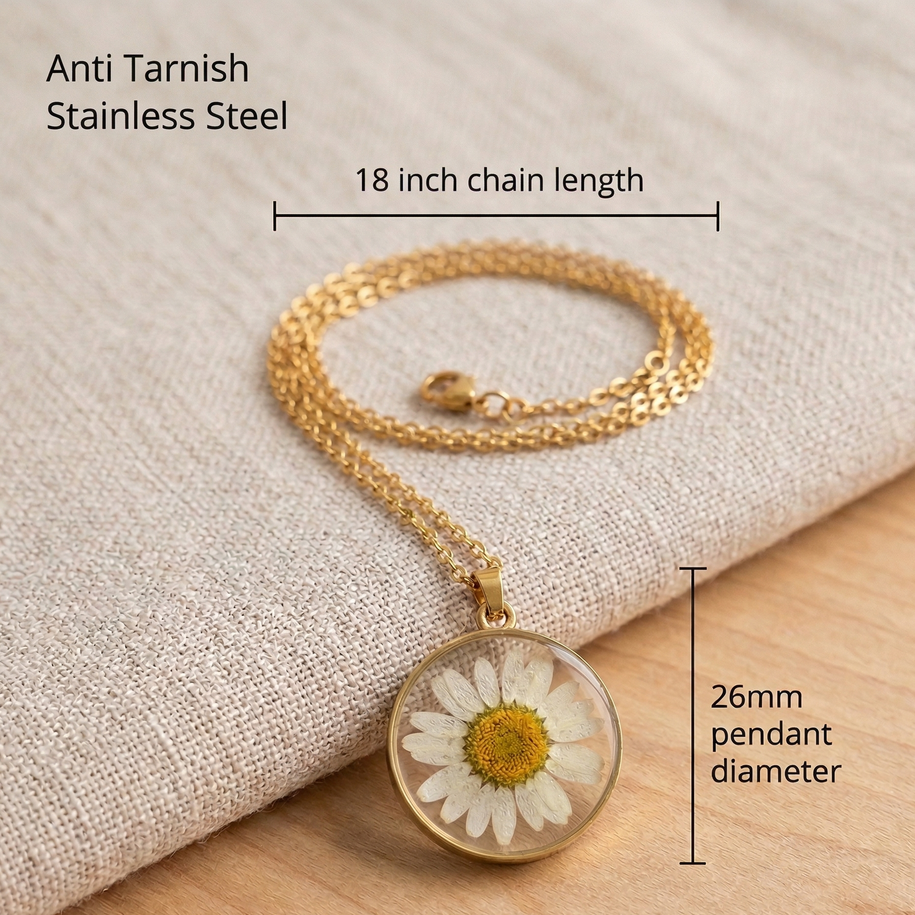Gold necklace with a daisy pendant on a beige fabric background